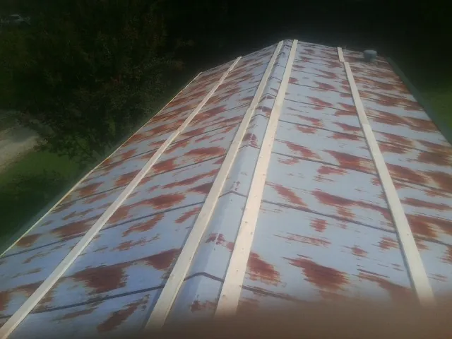 Rusted metal roof panels with new wood purlins before replacement — Storm Damage Roof Repair in Valencia by Roofing Brothers