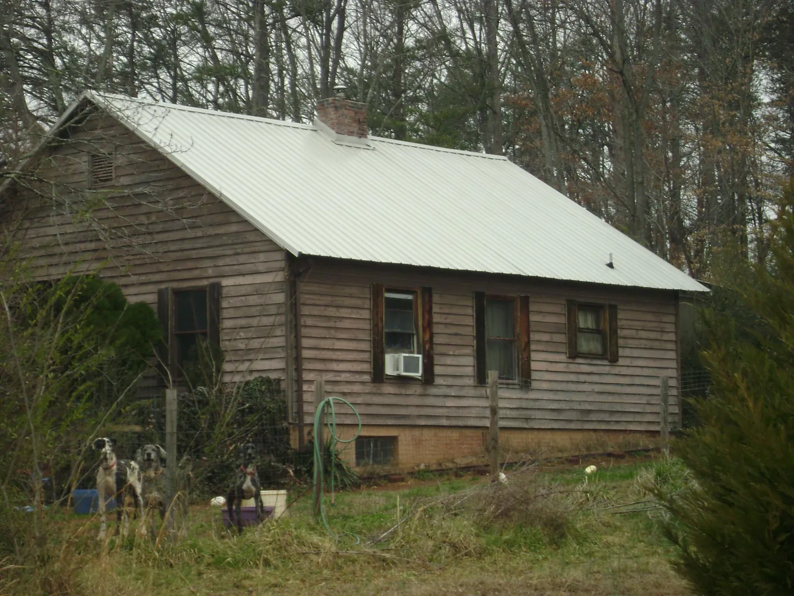 White metal roof on an old wood sided farmhouse, from a Metal Roof Installation job in Valencia